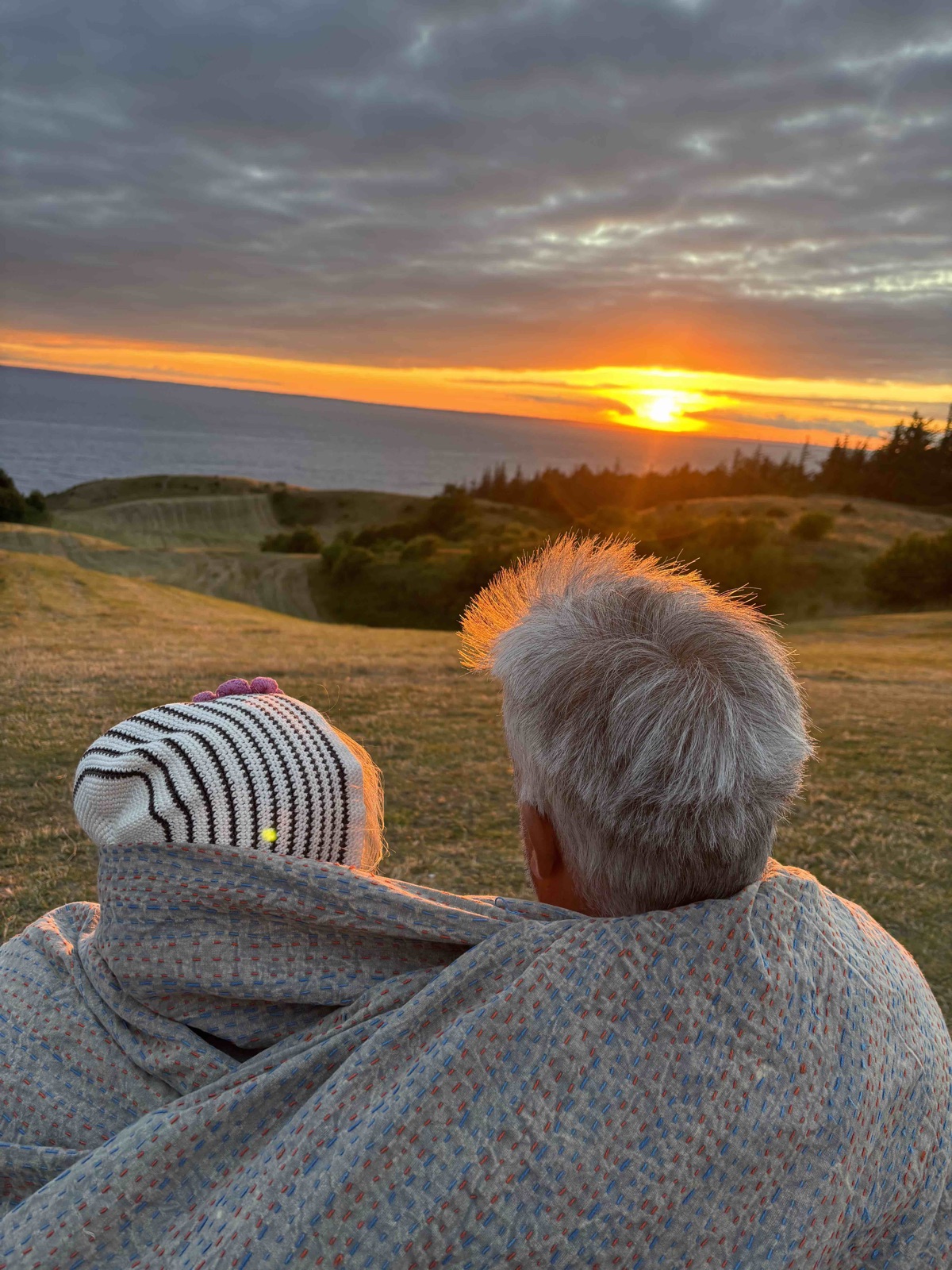 To mennesker, der sammen ser ud over en solnedgang